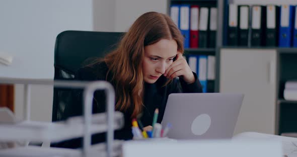 Tensed Businesswoman Working on Laptop in Office