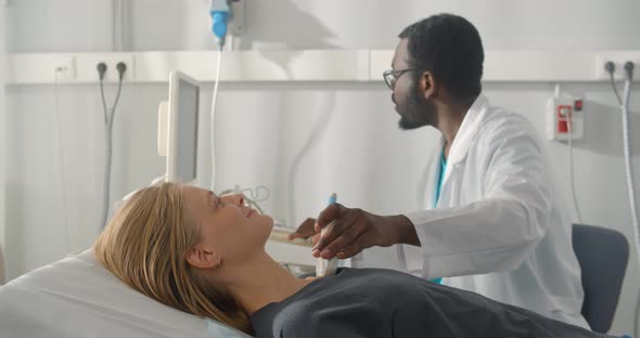 African Man Endocrinologist Making Ultrasonography To Female Patient in Ultrasound Office