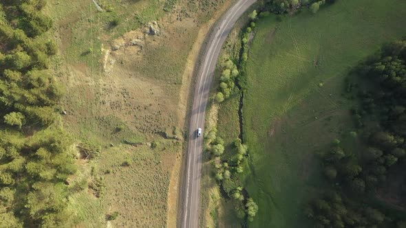 Aerial View Of A Mountain Road Among Forest And Meadows