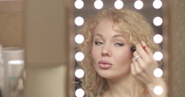 Blonde Looking at Mirror and Doing Makeup at Home