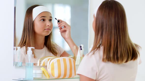 Teenage Girl Applying Mascara at Bathroom