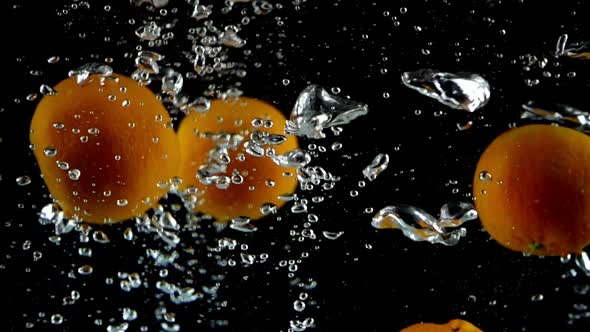 12 Tangerines Splashed into Water in Ultra Slow Motion- Black Background
