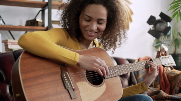 Inspired Happy Young Beautiful Latin Woman Play Melody on Acoustic Guitar and Beat Rhythm