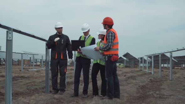 Supervisors with Blueprint at Solar Panels