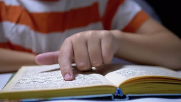 Child Runs Finger Along Page of Book and Reads Quickly