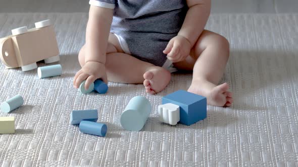 cute baby boy playing with eco wooden toys,train with carriages with cylinders and square form shape