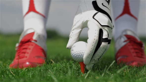 Female Golf Player Puts the Ball on the Tee