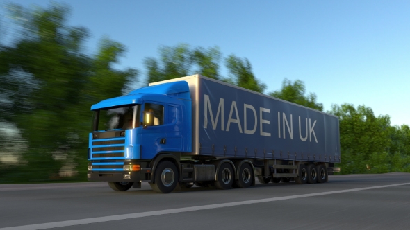 Speeding Freight Semi Truck with MADE IN UK Caption on the Trailer
