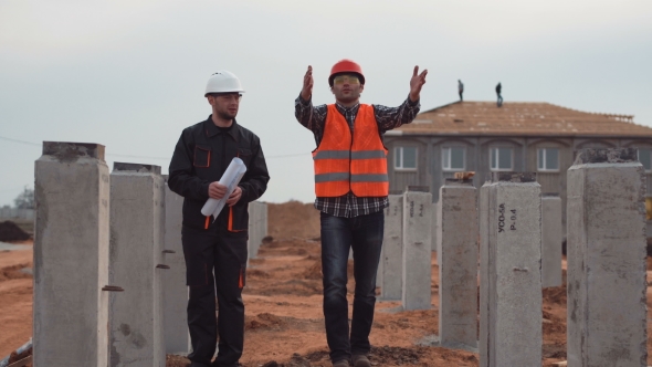 Workers Near Columns Discussing the Quality and Measurement