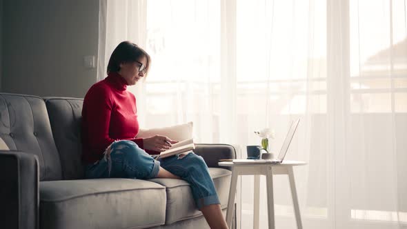 A Middleaged Woman in Glasses Talking on Video Call on the Laptop