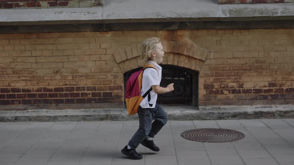 Happy Small Boy Running to Her Smiling Mother and Jumping Into Her Embrace After School