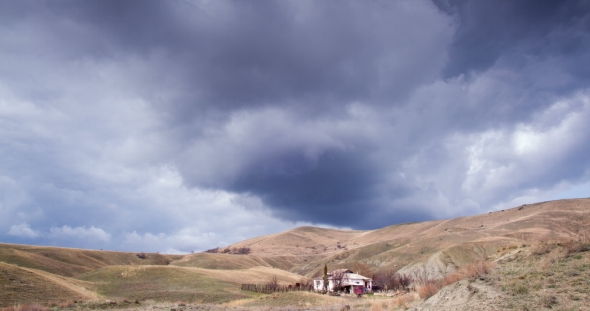 Cloudy Sky Above the House in the Hilly Valley