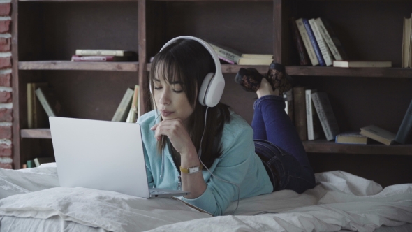 Woman in Headphones Working on a Laptop
