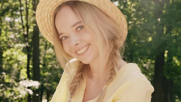 Portrait of young beautiful smiling hipster girl in trendy summer sundress posing outdoors