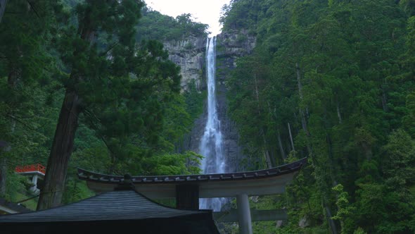 Nachi Falls Cascading Down Rocks Surrounded By Lush Green Forest. Locked Off, Low Angle