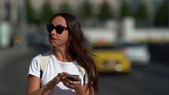 Female Tourist Is Orienting in New City By Map in Smartphone, Using Navigator at Mobile Phone