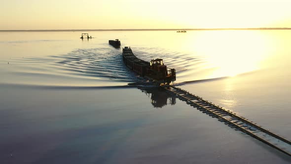 An Old Train Travels on a Railway Laid in the Water Across a Salt Lake