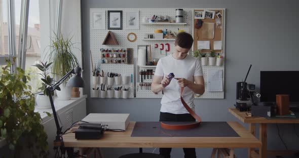 Leather Worker Grinding Edge Leather Belt During Manufacturing Process