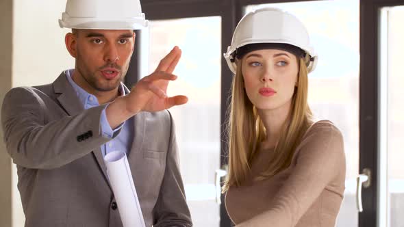 Architects with Blueprint and Helmets at Office