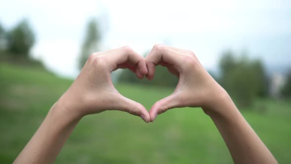 Teenager shows hands in the shape of a heart 