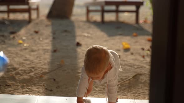 Toddler Runs Along the Beach and Climbs the Steps Into the Hotel Room