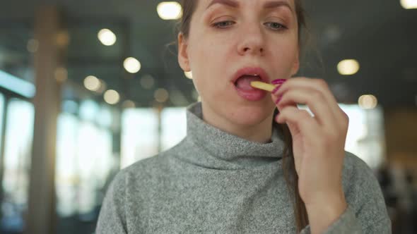 Woman Eating Fries in a Cafe Closeup