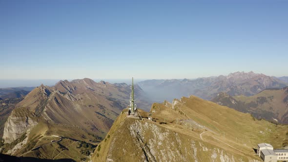 Aerial orbit around Rochers de Naye summit, parallax effect with the Alps in the background. Autumn