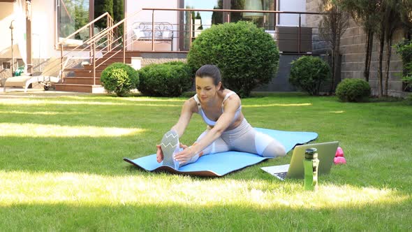 Fitness beautiful slim woman doing fitness stretching exercises outdoor at home. Sport, healthy life