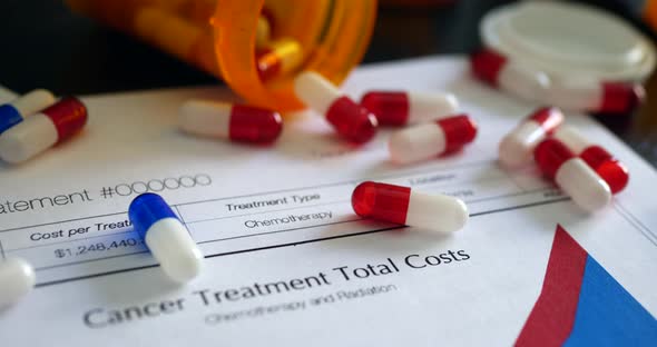 Cancer treatment drugs and pills on a prop health care insurance form showing high costs of chemothe