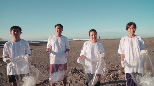 Asian Environmental Protectors On Polluted Beach