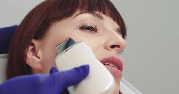 Professional Cosmetologist Working with Ultrasonic Facial Machine While Doing