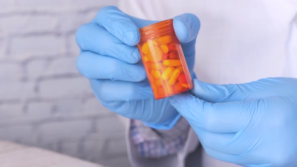 Doctor Hand in Protective Glass Holding Pill Container