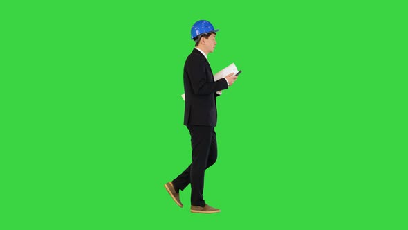 Architect Man Holding Blueprints Using Smartphone and Walking on a Green Screen Chroma Key