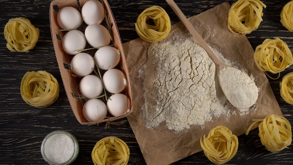 Pasta, Eggs and Flour on Wooden Background