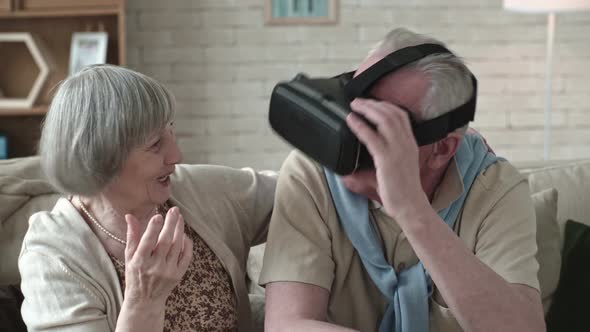 Gesturing Elderly Man in VR Headset