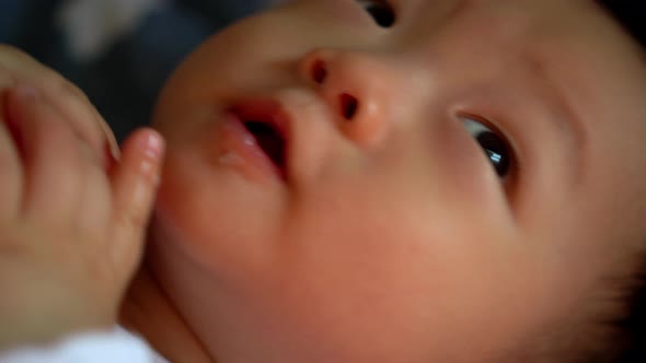 Close up face of cute Asia toddler boy lay at bed