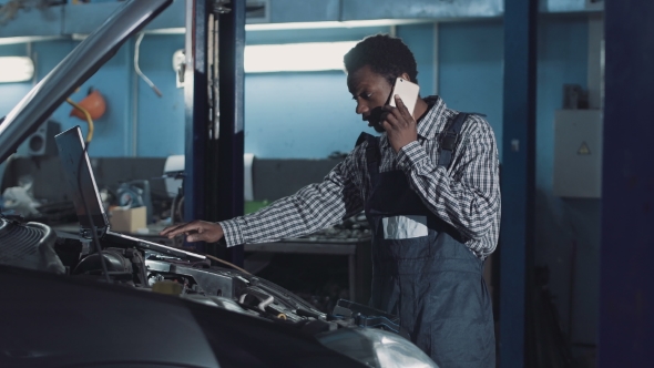 Man Talking Phone and Doing Engine Diagnostic