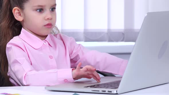 Little Girl Businesswoman Looking at Laptop and Decides Important Issues