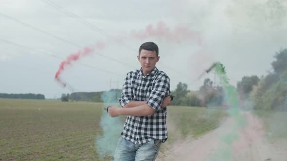 Young Man Spinning Colored Smoke Poi on Rural Road