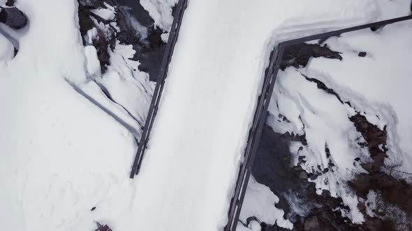 Aerial view of a small bridge over a creek in a snowy valley in the alps, Kleinwalsertal,Austria. Dr