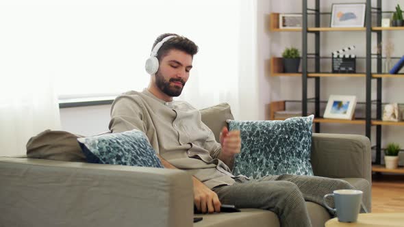 Man in Headphones Listening To Music on Smartphone