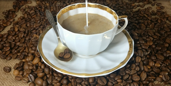 Pouring milk into the cup of fresh brewed coffee