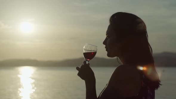 Slow Motion Video of a Girl Drinking Wine From a Glass at Sunset By the Sea