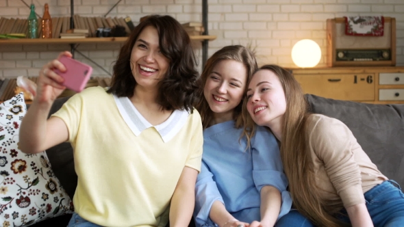 Three Young Female Best Friend Have Fun and Make Selfie on Mobile, Grimacing and Laughing