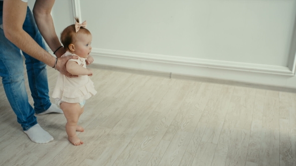 Dad Teaches His Little Daughter To Walk. Baby's First Steps
