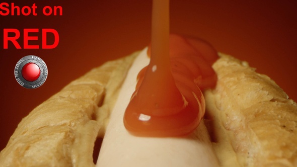 Ketchup Pouring On A Hot Dog With Sausage