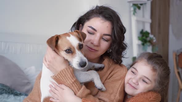 Young Mother Daughter in Knitted Sweaters are Sitting