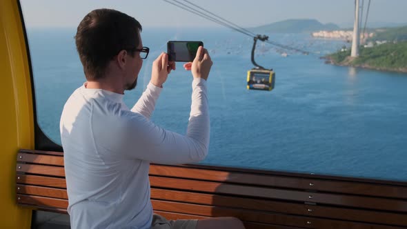 Tourist is Riding Cable Car Over Sea in Phu Quoc Filming By Smartphone