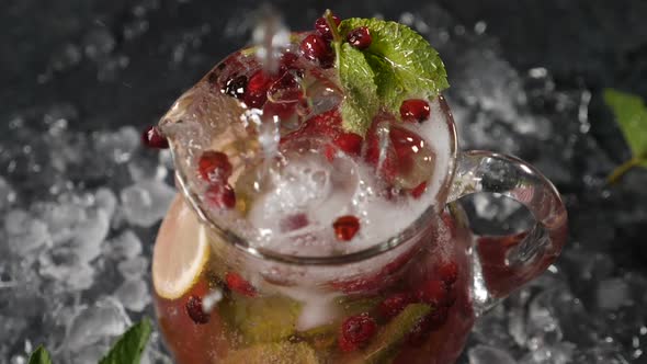 Aerated Cold Water Being Poured in Transparet Jar with Sliced Lime Berries and Ice Cubes