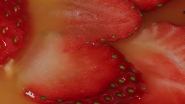 Macro shot of strawberries on a homemade cake with peach jam, close up view from above.